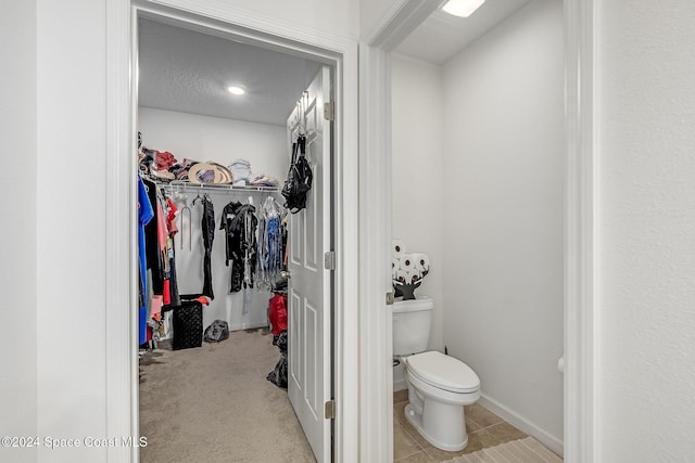 bathroom featuring tile patterned floors, a textured ceiling, and toilet