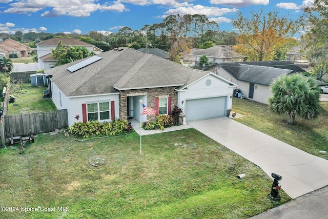 view of front facade with solar panels, a garage, and a front lawn