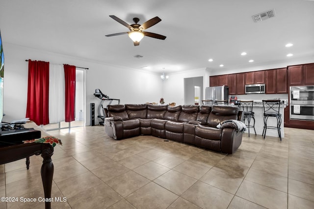 tiled living room with crown molding and ceiling fan with notable chandelier