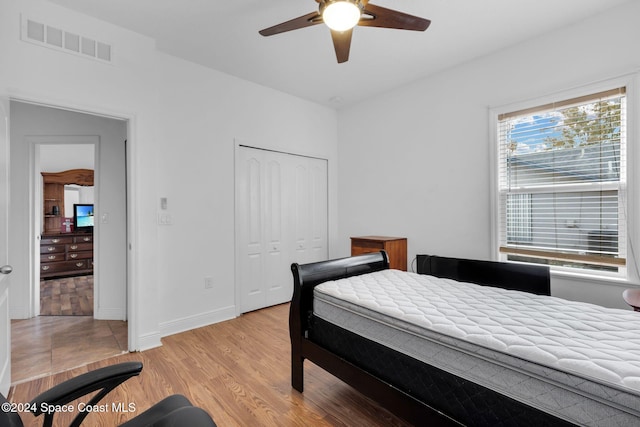 bedroom featuring light hardwood / wood-style flooring, a closet, and ceiling fan