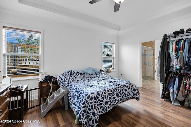 bedroom with hardwood / wood-style flooring, ensuite bath, ceiling fan, and crown molding