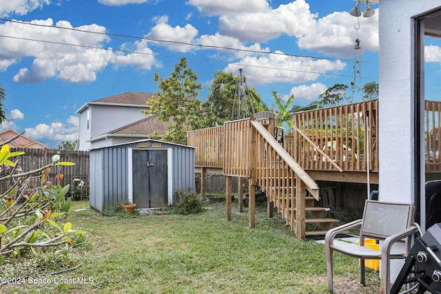 view of yard featuring a wooden deck and a storage unit