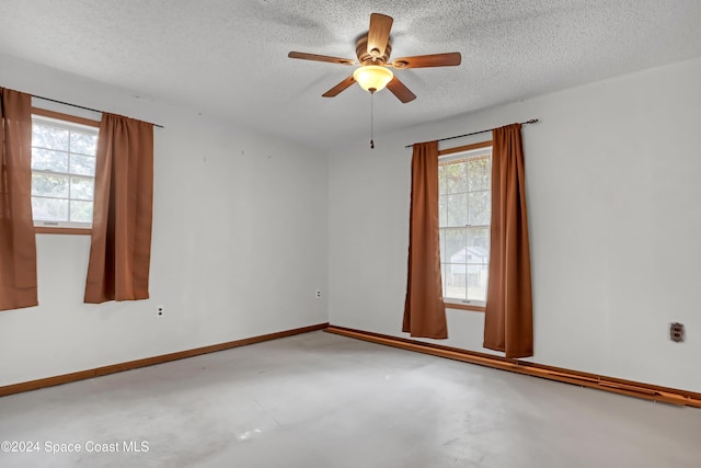 unfurnished room featuring ceiling fan, a textured ceiling, and concrete floors