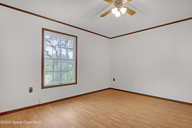 empty room featuring ceiling fan, light hardwood / wood-style floors, a textured ceiling, and ornamental molding