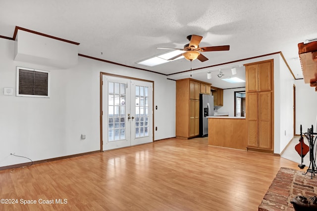 unfurnished living room featuring french doors, a textured ceiling, ceiling fan, crown molding, and light hardwood / wood-style flooring