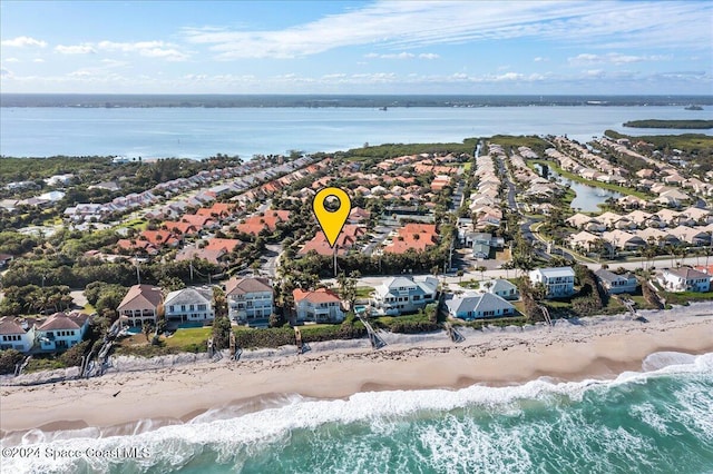 drone / aerial view featuring a water view and a beach view