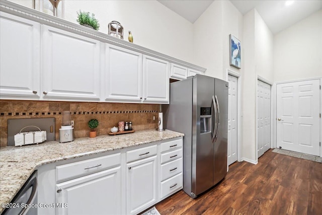 kitchen with dark wood-type flooring, light stone countertops, tasteful backsplash, white cabinetry, and stainless steel appliances