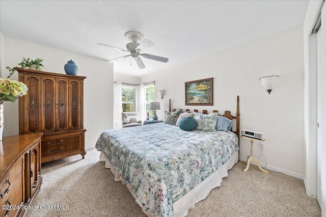 carpeted bedroom featuring ceiling fan, a closet, and a textured ceiling