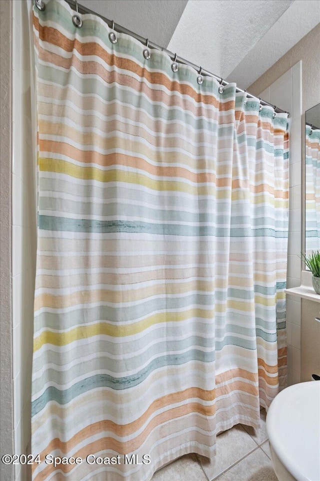 bathroom featuring tile patterned flooring and a textured ceiling