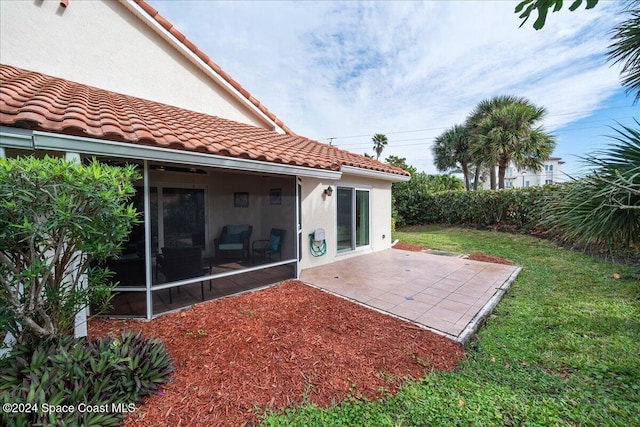 back of house featuring a patio area, a sunroom, and a yard