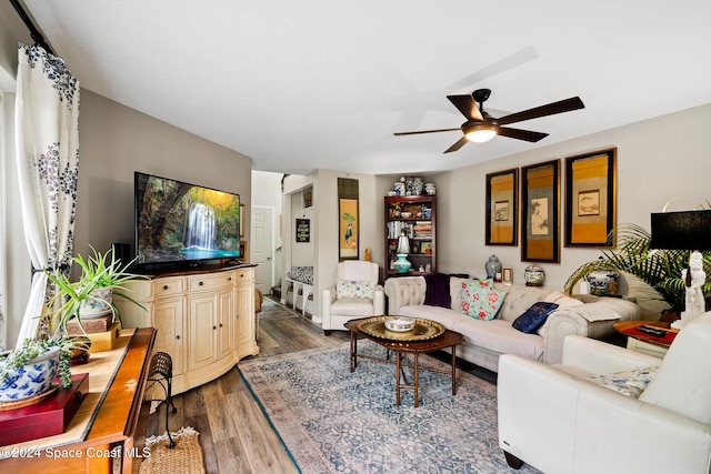 living room featuring ceiling fan and dark hardwood / wood-style flooring