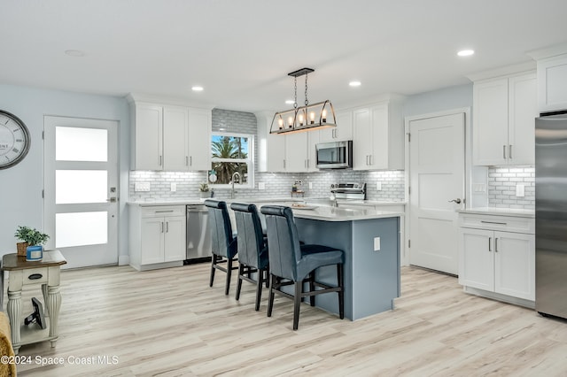 kitchen featuring white cabinets, light hardwood / wood-style floors, and appliances with stainless steel finishes