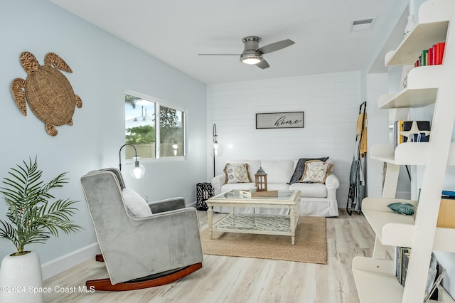 living room with ceiling fan and light hardwood / wood-style flooring