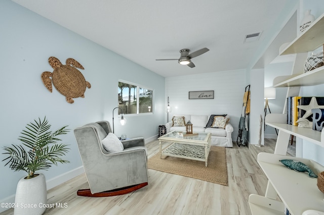 living room with light hardwood / wood-style flooring and ceiling fan