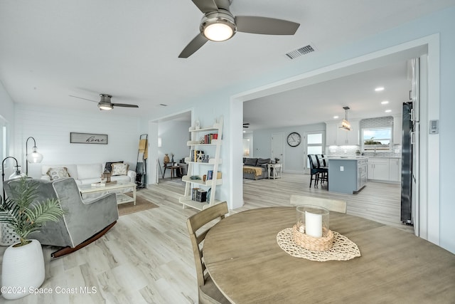 living room featuring ceiling fan and light hardwood / wood-style floors