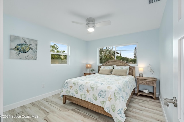 bedroom featuring multiple windows, ceiling fan, and light wood-type flooring