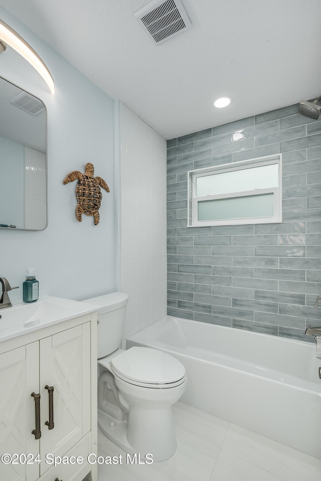 full bathroom featuring tile patterned floors, vanity, tiled shower / bath combo, and toilet