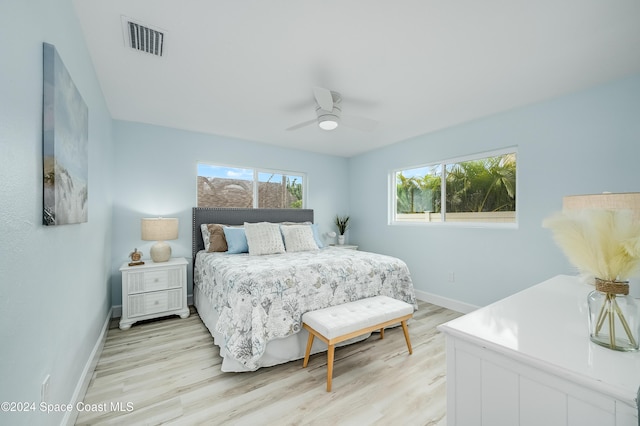 bedroom featuring multiple windows, ceiling fan, and light wood-type flooring