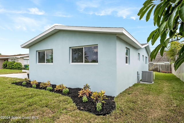 view of home's exterior featuring a yard and central AC unit