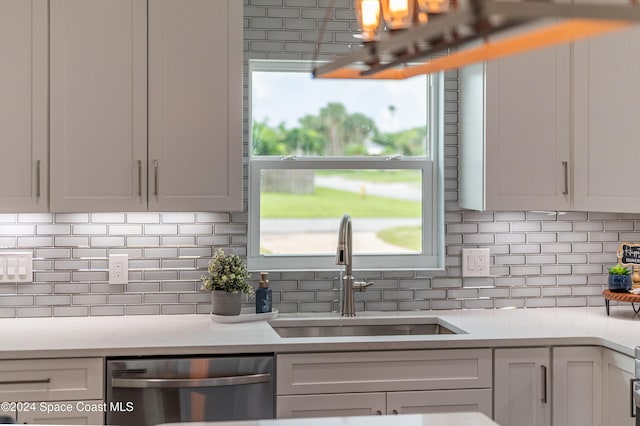 kitchen with white cabinets, stainless steel dishwasher, a healthy amount of sunlight, and sink