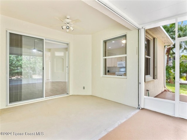 unfurnished sunroom with ceiling fan