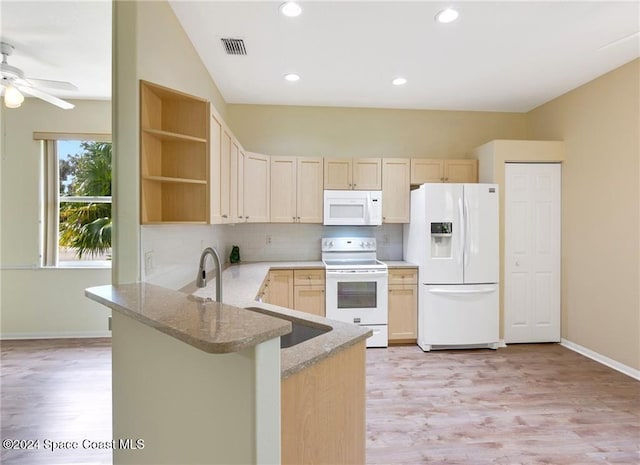 kitchen featuring kitchen peninsula, light stone counters, white appliances, light brown cabinets, and light hardwood / wood-style flooring