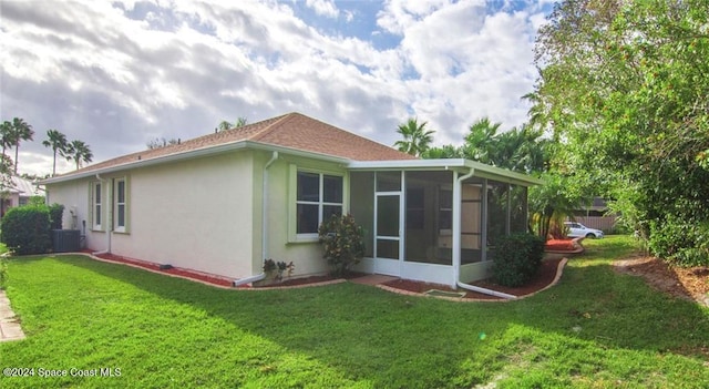 view of home's exterior with a lawn, central AC, and a sunroom