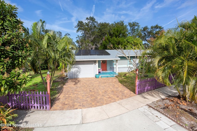 view of front of property with solar panels and a garage