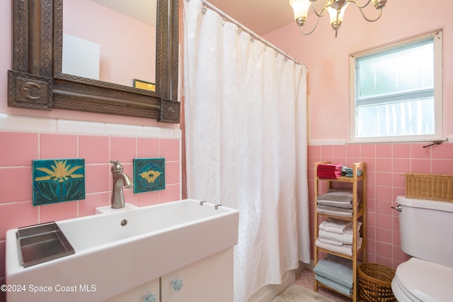 bathroom with a chandelier, toilet, tile walls, and sink