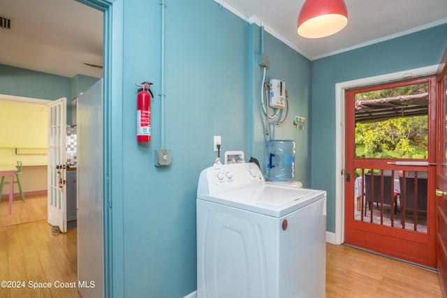 washroom with washer / dryer, light wood-type flooring, and ornamental molding