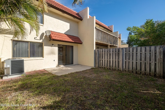 back of house featuring a patio, a lawn, and central air condition unit