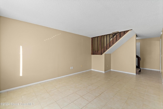 tiled spare room with a textured ceiling