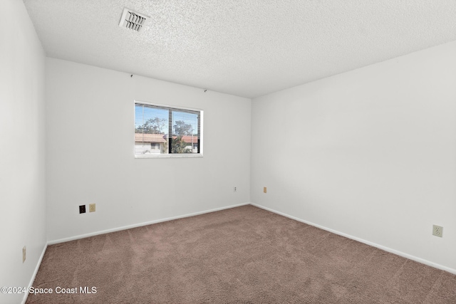 empty room with carpet flooring and a textured ceiling