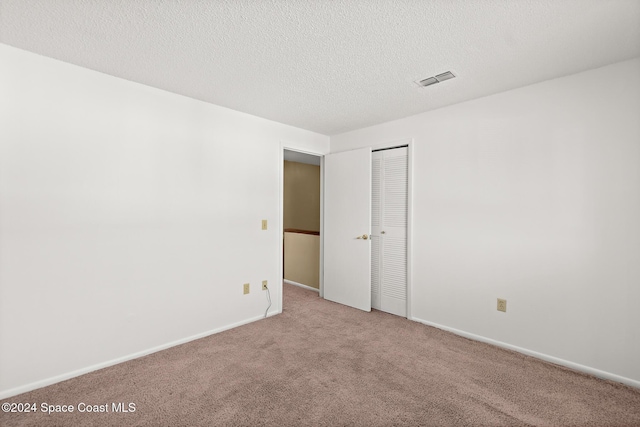 carpeted spare room featuring a textured ceiling