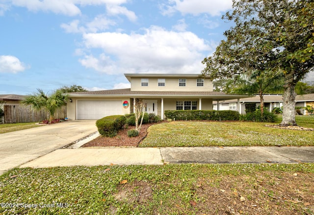 view of property featuring a front yard and a garage