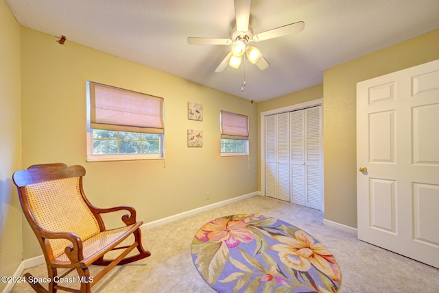 living area featuring ceiling fan and light colored carpet