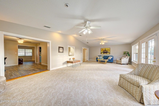 carpeted living room featuring french doors, a textured ceiling, ceiling fan, and lofted ceiling