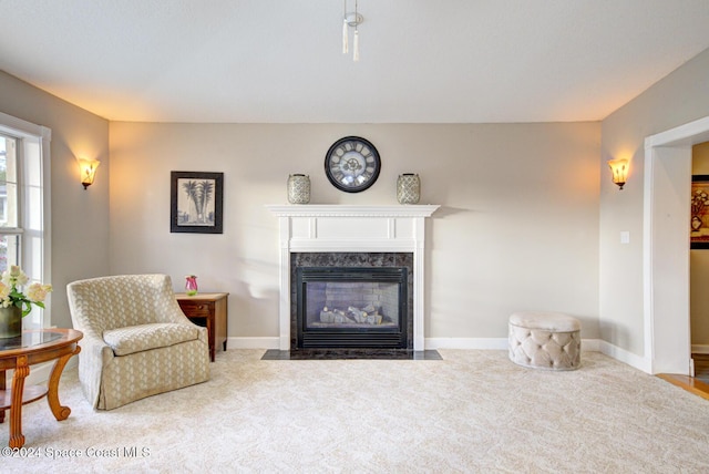 living room with a premium fireplace and light colored carpet