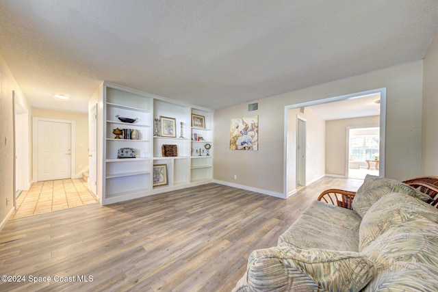 living room featuring wood-type flooring and a textured ceiling