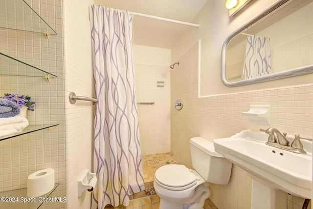 bathroom featuring tile patterned flooring, a shower with curtain, toilet, and tile walls