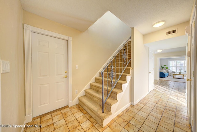 foyer entrance with a textured ceiling