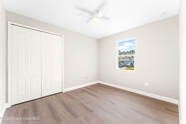 unfurnished bedroom with a closet, light hardwood / wood-style flooring, and ceiling fan