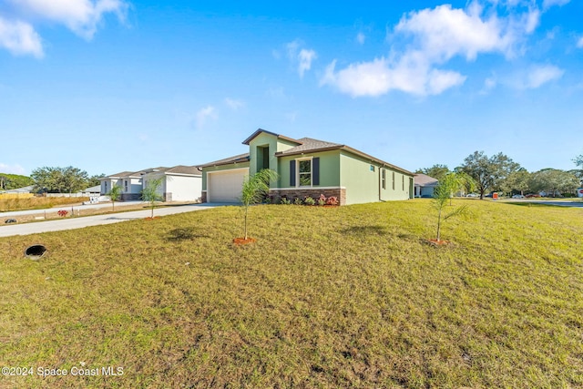 ranch-style house featuring a garage and a front lawn