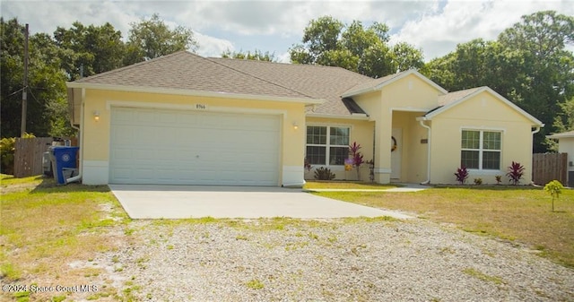 ranch-style home featuring a garage and a front lawn