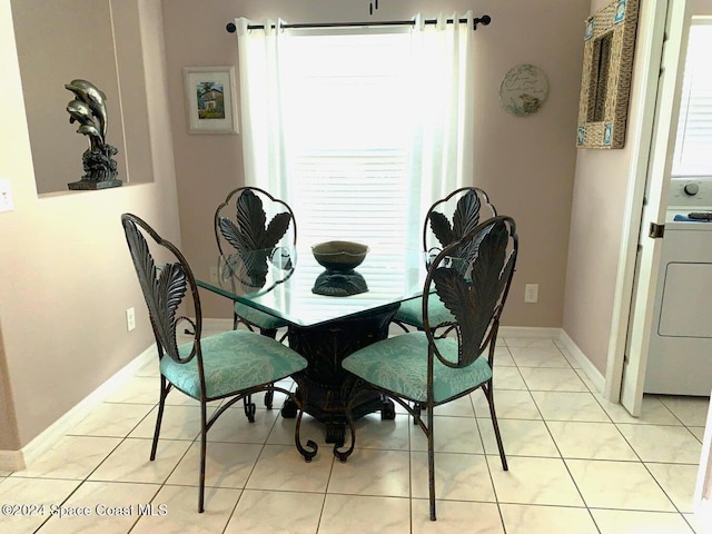 tiled dining area featuring washer / dryer