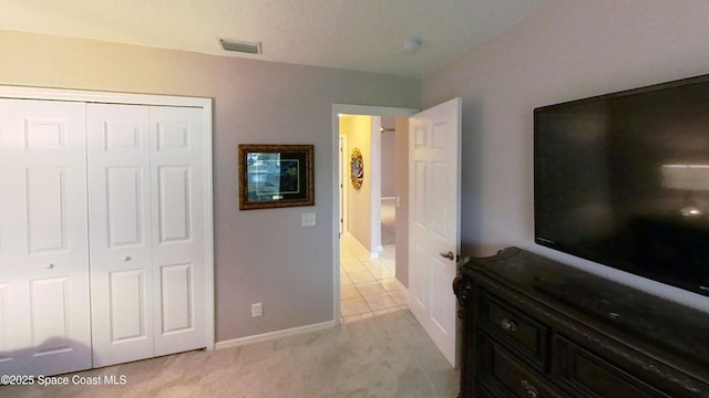 bedroom with light colored carpet and a closet