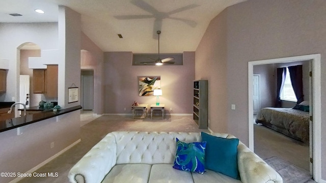 living room featuring light colored carpet, ceiling fan, and vaulted ceiling