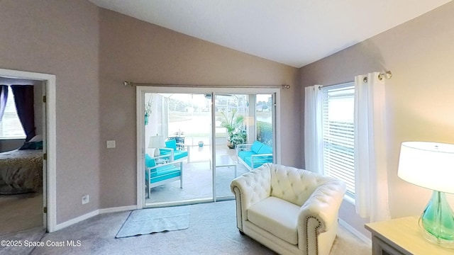 living area featuring vaulted ceiling and light colored carpet