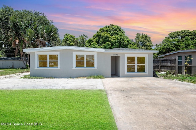 ranch-style home with a lawn