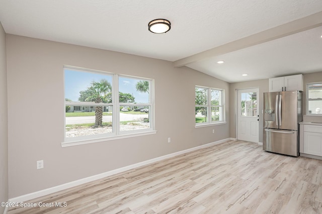 kitchen with white cabinets, stainless steel refrigerator with ice dispenser, lofted ceiling with beams, and light hardwood / wood-style floors